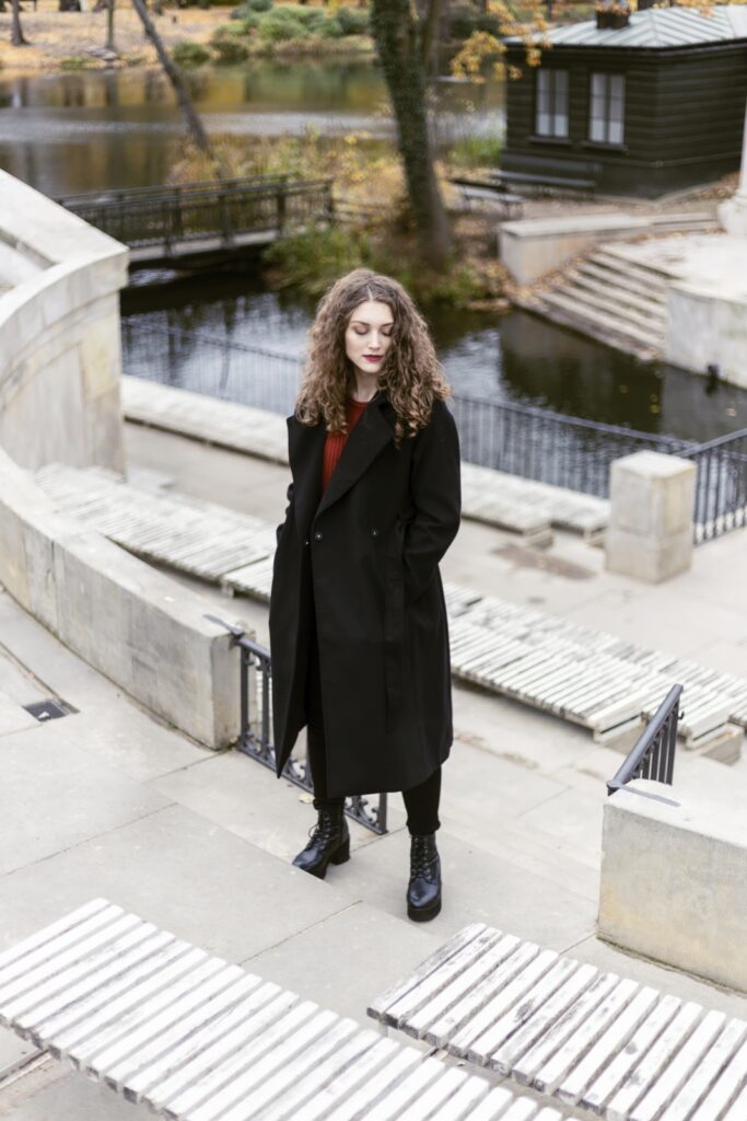 Jesienna sesja zdjęciowa z modelką w czarnym płaszczu