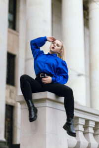 Sesja zdjęciowa Warszawa. Modelka w niebieskiej koszuli na tle Pałacu Kultury